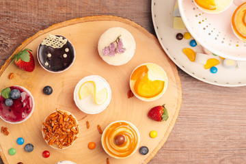 Delicious cupcakes with berries on white table, top view