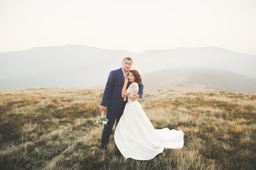 Beautiful gorgeous bride posing to groom and having fun, luxury ceremony at mountains with amazing view, space for text, wedding couple
