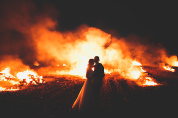 Amazing wedding couple near the fire at night