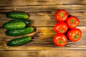 Fresh tomatoes and cucumbers on wooden table