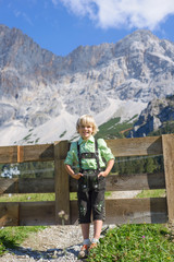 Fototapeta na wymiar Smilling Bavarian boy in a beautiful mountain landscape.Happy little boy wearing a traditional Bavarian clothes