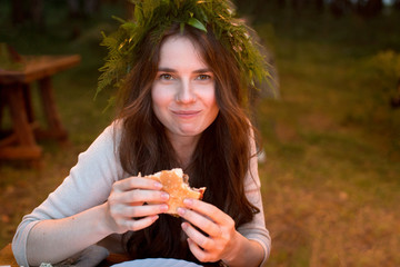 Delighted woman eating hamburger