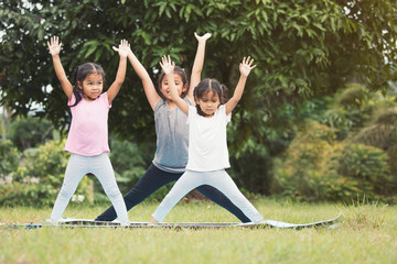 Happy children doing exercise together in outdoor in summer time