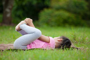 Cute asian little child girl doing exercise in the summer park