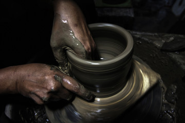Hands working on pottery wheel