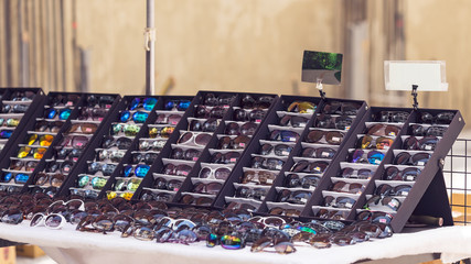 fashion sunglasses on shelf in flea market with beautiful bokeh, selective focus, filter effect