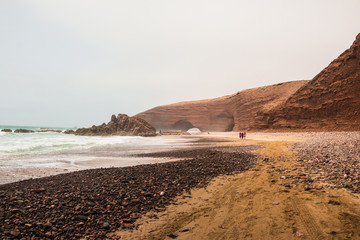Coast, waves and beach with yellow sand and pebbles