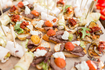 Assorted canape with cheese, meat, rolls, bakery and vegetables. selective focus