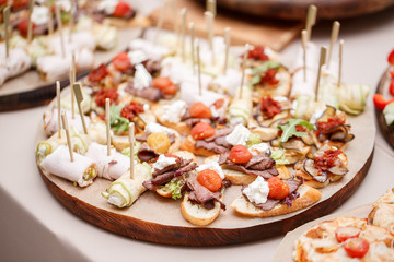 Assorted canape with cheese, meat, rolls, bakery and vegetables. selective focus