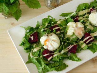 Poached eggs on a salad with pieces of beetroot. View from above