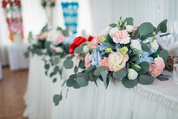 The many flowers stand on the wedding table