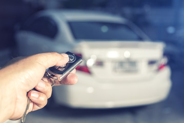 Men's hand presses on the remote control car alarm systems