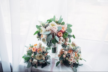 Dreamy wedding bouquet of roses and peonies stands on the windwosill