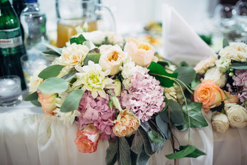 Bouquet of orange and pink flowers stands on the table