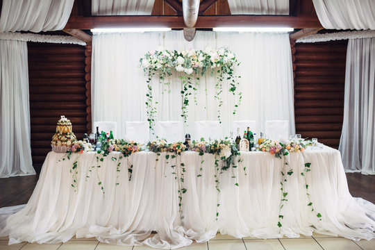 Dinner table for newlyweds decorated with greenery