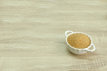 CANE SUGAR
cane sugar in a white bowl on the wood table.

