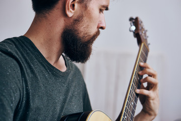 A man with a beard on a light background holds a guitar, play, musical instruments, music, strings