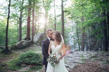 Stunning wedding couple poses in the forest