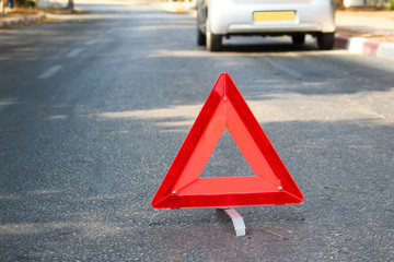 A broken car in the middle of the road in summer