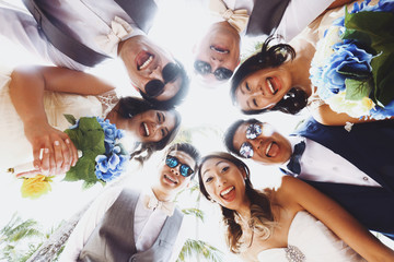 Look from below at newlyweds and friends hugging outside