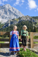 Smilling Bavarian children in a beautiful mountain landscape. Happy little children wearing a traditional Bavarian clothes