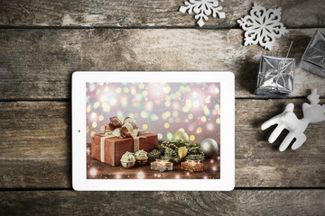Tablet and Christmas decor on wooden background