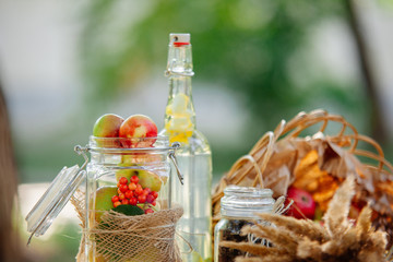 Summer picnic outdoor. Bright and colorful hipster lunch in the park. Lemonade in botle and jar of red apples.