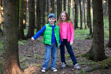 Children stand and hold hands in the forest