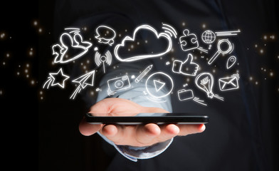 Hand of a man holding device with internet icons all around