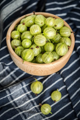 Fresh gooseberry in a wooden bowl.