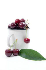White cup with red sweet cherry isolated on a white background..