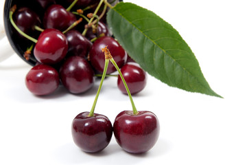 White cup with red sweet cherry isolated on a white background..