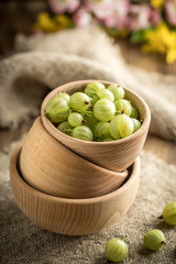 Fresh gooseberry in a wooden bowl.
