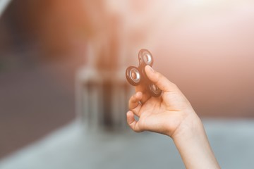 Little child boy playing with fidget spinner outdoors