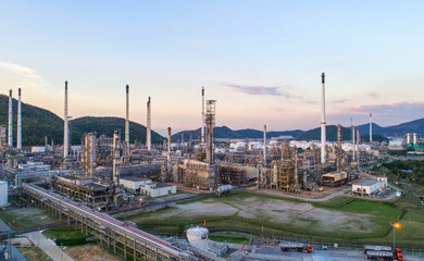 Obraz premium Aerial view Oil refinery with a background of mountains and sky.The factory is located in the middle of nature and no emissions. The area around the air pure.