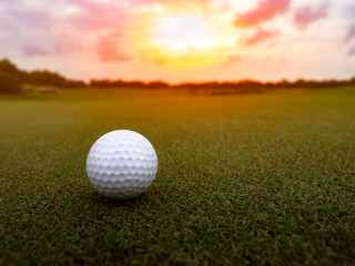 Golf ball on the green grass in beautiful golf course at sunset background, happy golf game