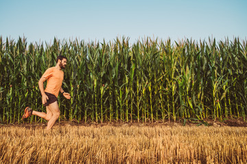 Uomo che corre in un campo di grano in campagna