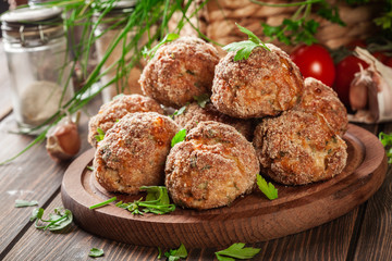 Stack of baked meatballs on a chopping board