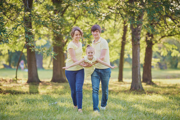 Fototapeta premium Happy family in the park on a tree background.