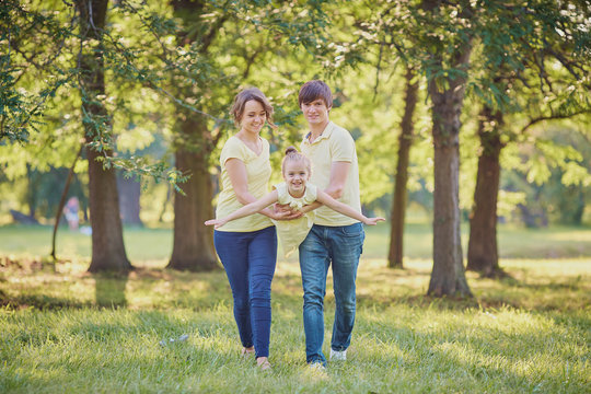 Happy family in the park on a tree background.