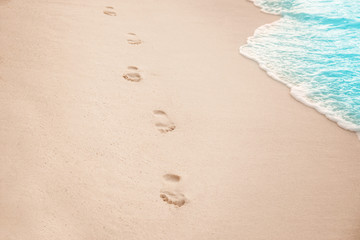 Fototapeta na wymiar Human footprints on beach sand at resort