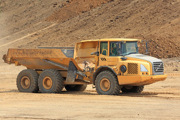 A powerful yellow tipper in a sandy quarry