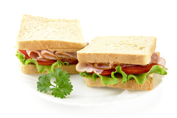 Sandwiches with lettuce,tomato,cold cuts with parsley on white