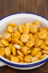 salted lupins in dish on wooden background