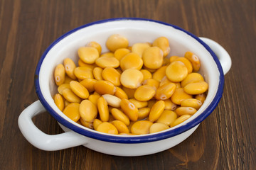 salted lupins in dish on wooden background