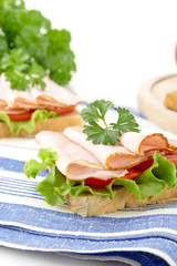 Cropped view of breakfast sandwiches with parsley on kitchen towel