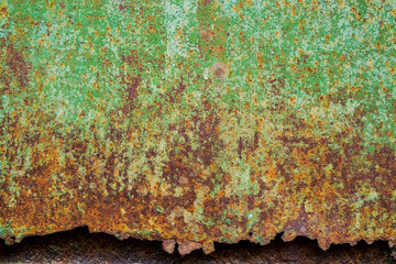 Rusty metal surface with cracked green paint