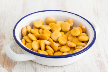 salted lupins in dish on wooden background