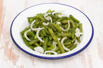 boiled green beans in dish on wooden background