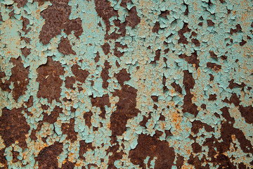 Rusty metal surface with cracked green paint
